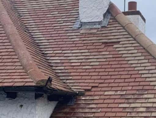 This is a photo taken in Sevenoaks of a roof that needs repair. The tiles have slipped and the roof is in poor condition